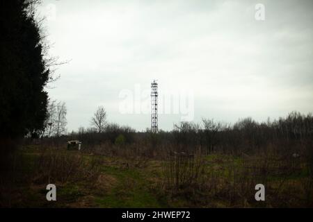 Antenna in field. Radio signal tower. Tower for radio signal transmission. Landscape with technical object. Stock Photo