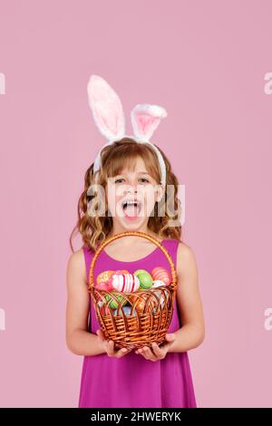 Happy kid showing basket with decorated eggs during Easter celebration Stock Photo