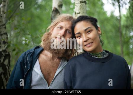 A guy of European appearance and a girl of Asian appearance. Portrait of lovers. Interracial couple. Young people are happy to meet. Emotions on the f Stock Photo