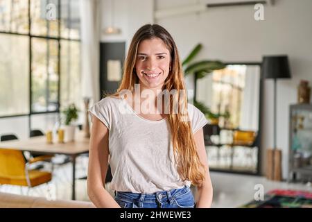 Cheerful beautiful blond caucasian woman standing at home looking at camera. Happy confident entrepreneur lady laughing face posing alone, head shot Stock Photo