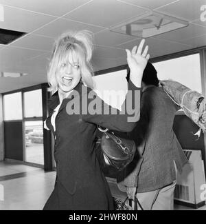 Goldie Hawn, American actress at London Heathrow Airport, Saturday 4th July 1970. Goldie and husband Gus Trikonis (holding carpet) are flying to their Los Angeles home. Stock Photo