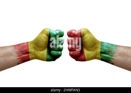 Two hands punch to each others on white background. Country flags painted fists, conflict crisis concept between guinea and guinea Stock Photo