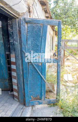 Old disintegrating destroyed  barn door with old wooden panels plates Opened broken old barn doors Stock Photo