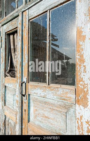 Old disintegrating destroyed  barn door with old wooden panels plates Stock Photo