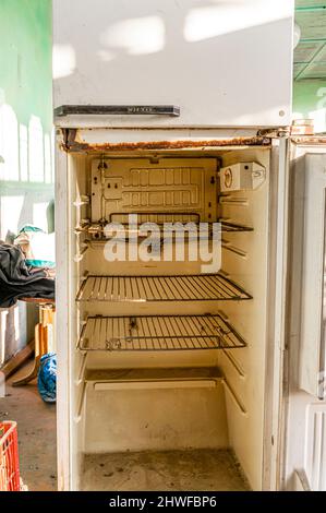 Old empty soviet MZH refridgerator. Opened empty neglected non-working fridge. Stock Photo