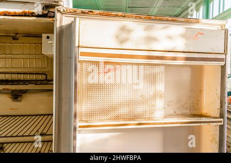 Old empty soviet MZH refridgerator. Opened empty neglected non-working fridge. Stock Photo