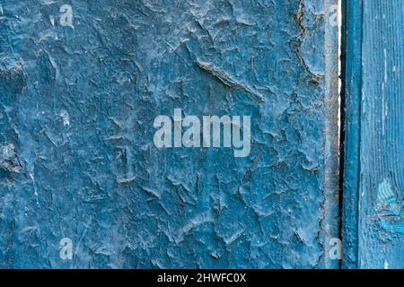 Blue paint peeled on an old wooden door with paint weathered Stock Photo