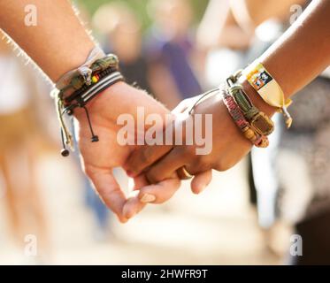 Cross-cultural friendship. Cropped closeup view of a multi-ethnic couple holding hands. Stock Photo