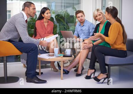 Teamwork means everyones opinion is valued. A team of coworkers sitting in their office having a meeting. Stock Photo