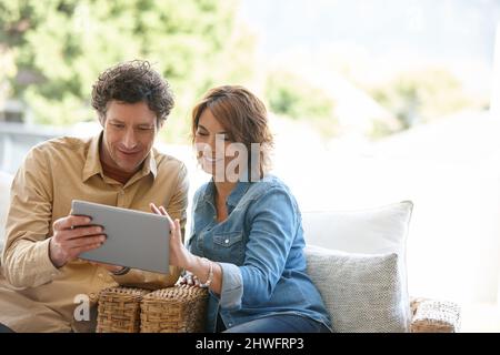 Logging into their joint email account. Shot of a husband and wife using a digital tablet together at home. Stock Photo