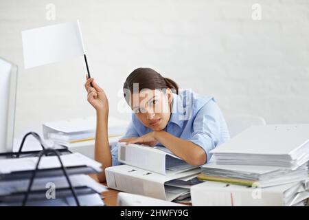 I surrender. Shot of a young businesswoman holding up a white flag and looking defeated. Stock Photo