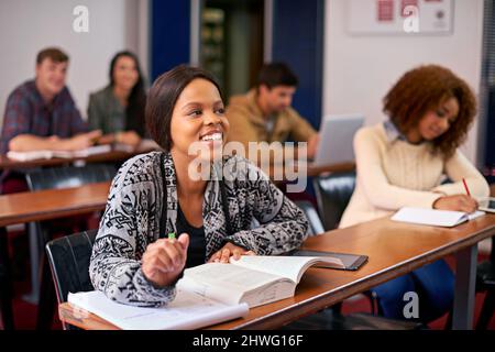 Furthering their education. Shot of a happy student paying attention in class. Stock Photo