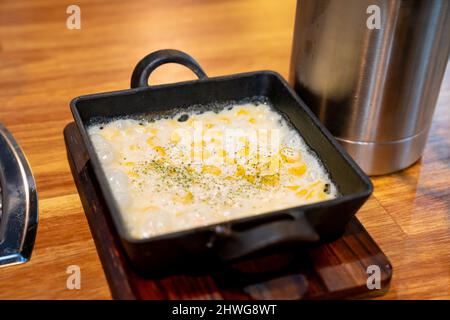 Korean style corn, cheese and mayonnaise, in a black pot, taken in a restaurant Stock Photo