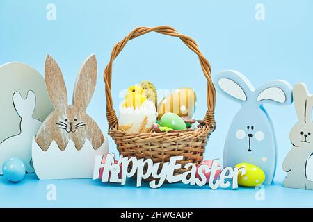 whiteeggs in the nest and yellow chicks on a blue background.  An Easter card with a copy of the place for the text. Stock Photo