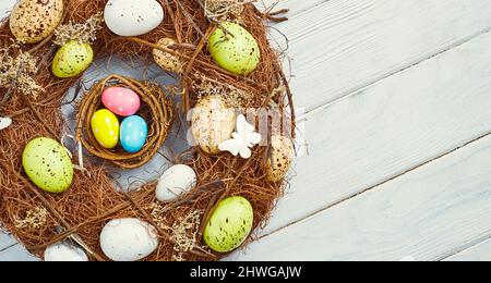 Coloeful easter eggs in nest on pink color background with space. Minimal concept. Card with copy space for text. Stock Photo