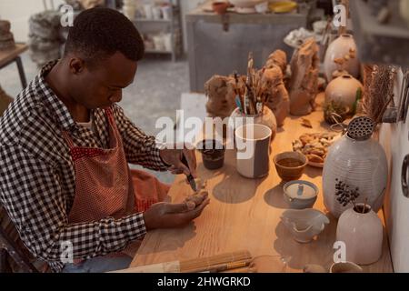 Focused ceramic artist working in his studio Stock Photo