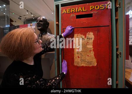 Museum creator Louisa Knight checks over a post box of England's first Aerial post service from around 1911, on display at the Windsor and Royal Borough Museum in the Guildhall, Windsor, Berkshire, following its re-opening after a two year closure due to the coronavirus pandemic. Picture date: Friday March 4, 2022. Stock Photo