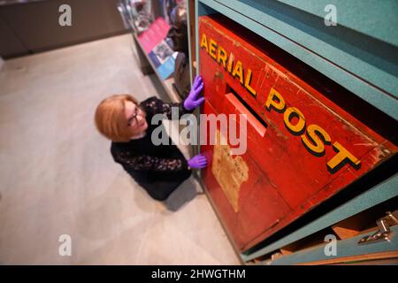 Museum creator Louisa Knight checks over a post box of England's first Aerial post service from around 1911, on display at the Windsor and Royal Borough Museum in the Guildhall, Windsor, Berkshire, following its re-opening after a two year closure due to the coronavirus pandemic. Picture date: Friday March 4, 2022. Stock Photo