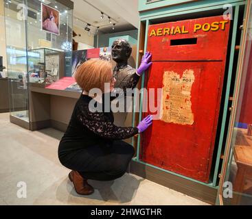 Museum creator Louisa Knight checks over a post box of England's first Aerial post service from around 1911, on display at the Windsor and Royal Borough Museum in the Guildhall, Windsor, Berkshire, following its re-opening after a two year closure due to the coronavirus pandemic. Picture date: Friday March 4, 2022. Stock Photo