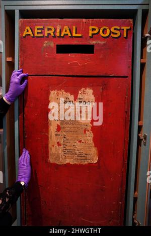 Museum creator Louisa Knight checks over a post box of England's first Aerial post service from around 1911, on display at the Windsor and Royal Borough Museum in the Guildhall, Windsor, Berkshire, following its re-opening after a two year closure due to the coronavirus pandemic. Picture date: Friday March 4, 2022. Stock Photo