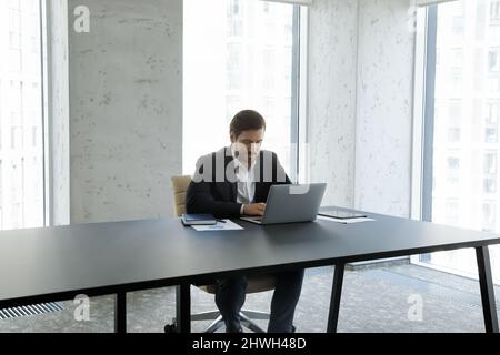 Focused young Caucasian businessman working on computer. Stock Photo