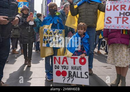 New York, United States. 05th Mar, 2022. Vlad, age 9, and Jarek, age 4, draped in Ukrainian flag and holding signs attend the 'Stand With Ukraine' rally in Times Square on March 5, 2022 in New York City. Ukrainians, Ukrainian-Americans and allies gathered to show support for Ukraine and protest against the Russian invasion. (Photo by Ron Adar/SOPA Images/Sipa USA) Credit: Sipa USA/Alamy Live News Stock Photo