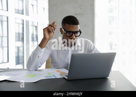 Concentrated young African American businessman working on online project. Stock Photo