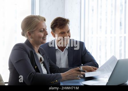 Happy middle aged business people working on computer. Stock Photo