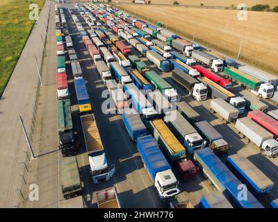 Lots of trucks with trailers in the parking lot. Queue for unloading at the port. Stock Photo