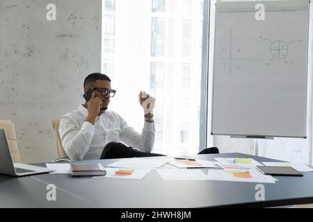 Serious African American male manager solving problems by phone call. Stock Photo