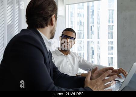 Young two diverse business partners discussing online project. Stock Photo