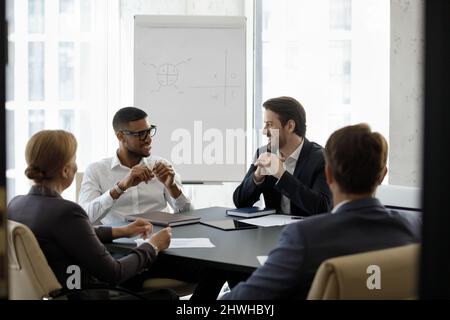 Happy relaxed multiracial business people talking in boardroom. Stock Photo
