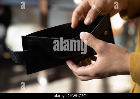 Hands of young African woman opening empty black wallet Stock Photo