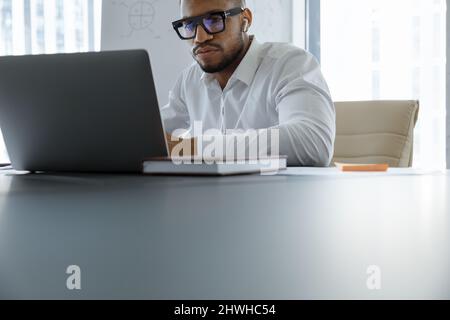 Thoughtful young African American working on computer. Stock Photo