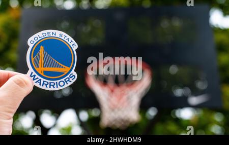 September 15, 2021, San Francisco, USA, A man holds the emblem of the basketball club Golden State Warriors on the sports ground. Stock Photo