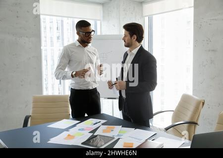 Focused multiracial employees discussing working issues in office. Stock Photo