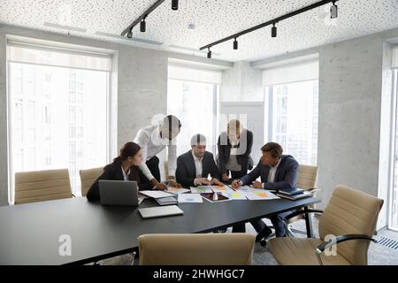 Concentrated successful happy diverse colleagues analyzing financial paper documents. Stock Photo