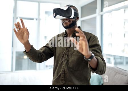 Virtual reality isnt so science fiction anymore. Shot of a young businessman using a virtual reality headset in a modern office. Stock Photo