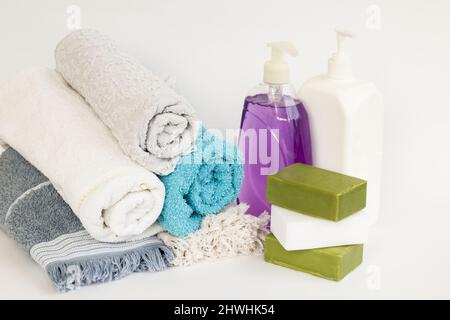 https://l450v.alamy.com/450v/2hwhk54/rolled-up-multi-color-bath-and-face-towels-on-white-background-with-natural-olive-oil-soaps-and-liquid-soap-2hwhk54.jpg