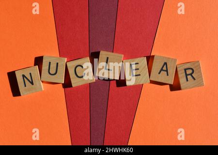 Nuclear, word in wooden alphabet letters isolated on red and orange background Stock Photo
