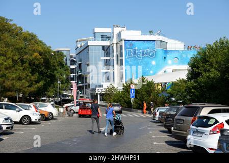 ODESA, UKRAINE - SEPTEMBER 25: The young family with baby carriage goes from car parking to Nemo Odessa dolphinarium. It is located on Lanzheron beach Stock Photo