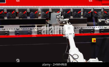 Robot arm loading metal sheet to CNC Synchronize Hydraulic press brake bending machine. Industrial metalworking machinery Stock Photo