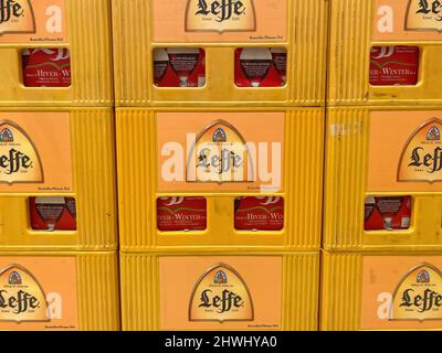 Liege, Belgium - March 3. 2022: Closeup of beer crates with bottles with logo lettering of belgian abbey brewery leffe in supermarket Stock Photo