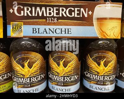 Liege, Belgium - March 3. 2022: Closeup of six pack beer bottles with logo lettering of belgian grimbergen brewery Stock Photo