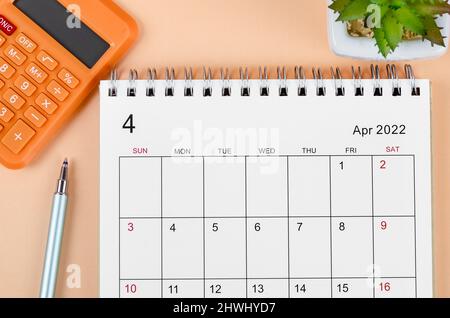 The April 2022 desk calendar with calculator on beautiful background. Stock Photo