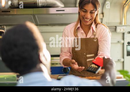 Black man making payment with smartphone in food truck Stock Photo
