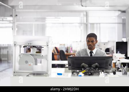 3D printing is the way forward. Cropped shot of a young man printing his designs on a 3D printer. Stock Photo