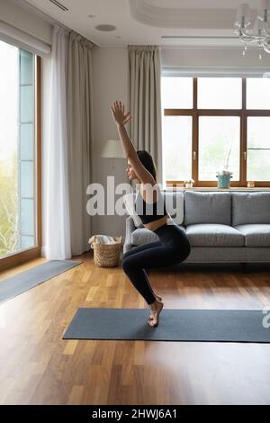 Beautiful slim woman practicing yoga at home Stock Photo
