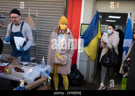 Glasgow, UK, 6th March 2022. Crowds gather to buy bakery goods, cakes and breads from the Deanston Bakery, owned by Ukrainian baker Yuriy Kachak, with all proceeds going to charities working in war torn Ukraine, in Shawlands, Glasgow, Scotland, 6 March 2022. Photo credit: Jeremy Sutton-Hibbert/Alamy Live News. Stock Photo