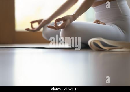 Cropped image woman do meditation practice sit cross-legged on mat Stock Photo